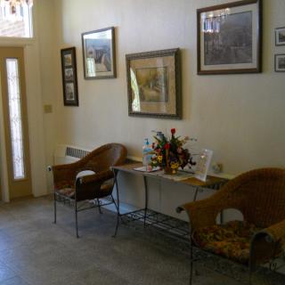 A cozy waiting room with chairs, artwork on the walls, and decorative pieces on a table.