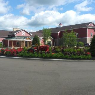 A picturesque building surrounded by a well-maintained garden under a cloudy sky.