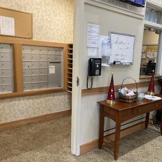 A view of a reception area featuring mailboxes, a phone, and a decorative table.