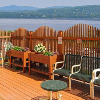 A scenic patio with comfortable seating and planter boxes overlooking a lake.