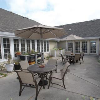 A spacious outdoor patio area featuring tables with umbrellas and chairs.