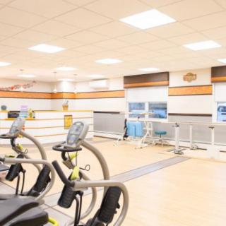 A modern fitness center with various exercise equipment and a spacious layout.