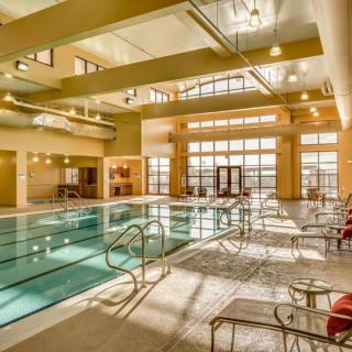 A spacious indoor swimming pool area with modern design and bright lighting.