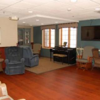 A cozy living room with multiple seating options and a television.