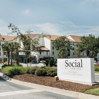 A view of a residential complex with a prominent entrance sign reading 'Social'.