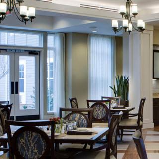 A well-lit dining area with multiple tables and chairs, featuring elegant interior design.