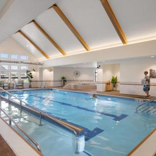 An indoor swimming pool with bright wooden beams and modern design.