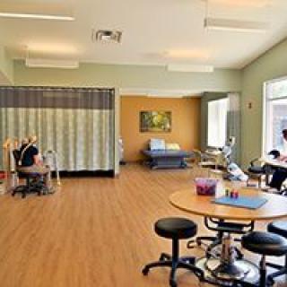 A clean and spacious physical therapy room equipped with various rehabilitation tools and exercise stations.