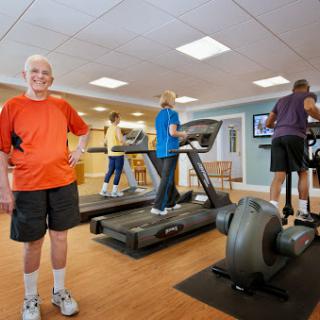 A group of seniors engaging in exercise at a gym, focusing on maintaining fitness and health.