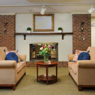 A cozy living room featuring comfortable sofas, a central coffee table, and a decorative fireplace.