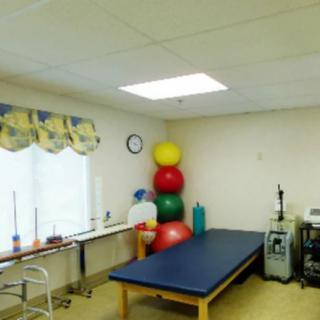 A physical therapy room equipped with exercise balls and medical equipment.