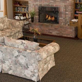 A cozy living room with a floral sofa facing a brick fireplace.