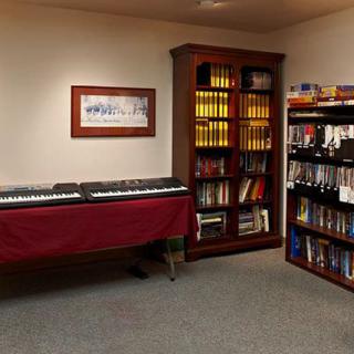A cozy music room with a keyboard and well-stocked bookshelves.