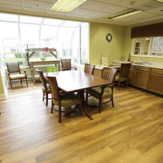 A spacious conference room with a large meeting table, chairs, and ample natural light from the windows.