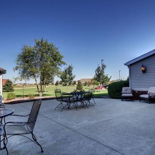 A spacious outdoor patio with seating and a view of the garden.