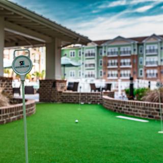An outdoor putting green area with surrounding residential buildings.