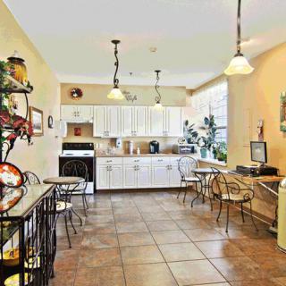 A bright and spacious kitchen and dining area with tiled floors, hanging lights, and ample counter space.