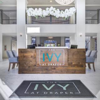 The modern reception area at The Ivy at Draper featuring a stylish wooden desk and elegant decor.