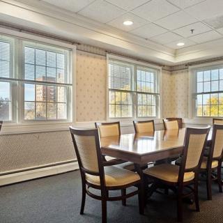 A well-lit conference room with a long meeting table and chairs.