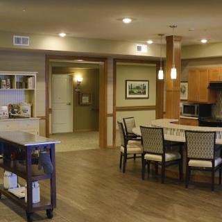 A modern kitchen and dining area with wood flooring and elegant furniture.