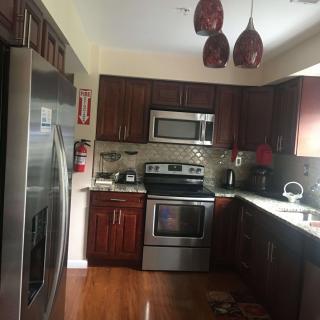A modern kitchen with stainless steel appliances and wooden cabinets.