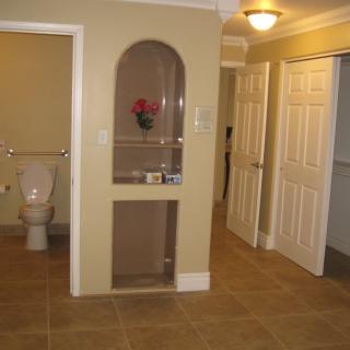 A view of a hallway with a bathroom and closet doors.