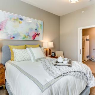 A cozy and modern bedroom with stylish decor and art.