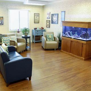 A cozy waiting room with comfortable seating, an aquarium, and modern decor.