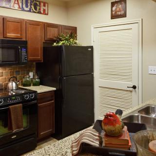 A cozy kitchen with modern appliances and wooden cabinets.