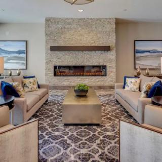 A stylish living room featuring a stone fireplace, modern sofas, and elegant decor.