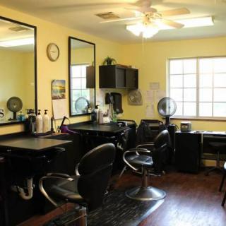 A well-lit hair salon interior with styling stations and chairs.