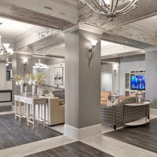 A modern hotel lobby featuring comfortable seating, elegant lighting, and a neutral color palette.