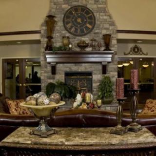 A luxurious living room featuring a stone fireplace, large clock, and elegant decor.