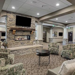A cozy lounge area featuring comfortable seating and a modern fireplace.