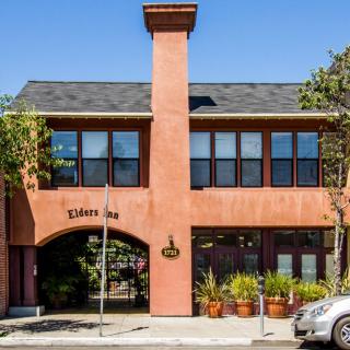 A street view of an inn with a prominent archway and brick facade.