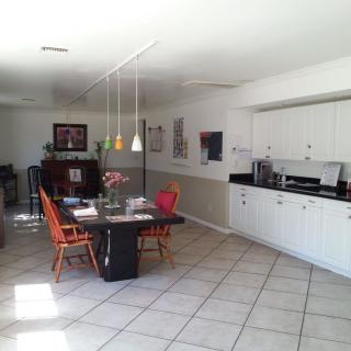A modern kitchen and dining area with a table, chairs, and pendant lighting.