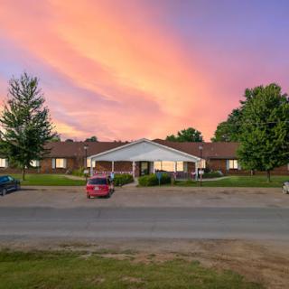 A picturesque sunset casts vibrant colors across the sky above a residential building.