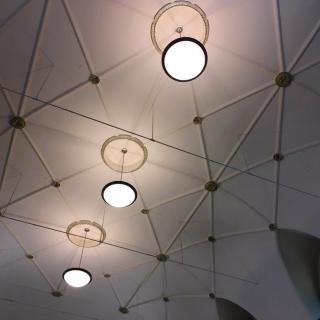A geometric ceiling design with circular lights.