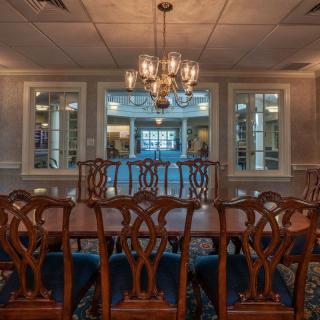 A traditional dining room with a large wooden table and an elegant chandelier.