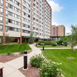 A modern apartment building with landscaped gardens and pathways.