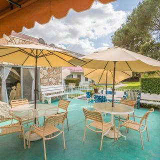 A relaxing outdoor patio area with tables, chairs, and large umbrellas on a sunny day.