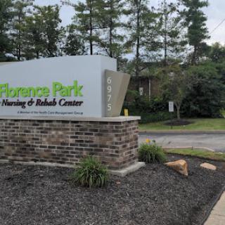 Entrance sign of a nursing and rehab center surrounded by greenery.