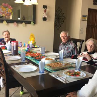 A warm gathering of friends enjoying a meal together at the dining table.