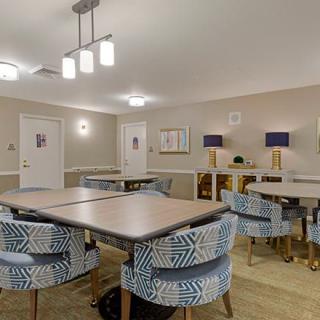 A modern meeting room with patterned chairs and well-lit tables.