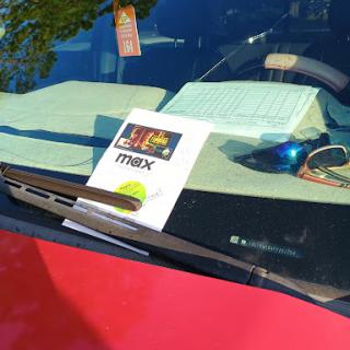 A note placed on the dashboard of a parked car.