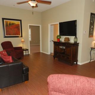 A cozy living room with comfortable seating, a television, and warm decor.