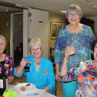 A group of women enjoying a gathering indoors with food and drinks.