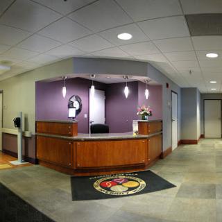 A modern reception area with a wooden counter and purple accents.
