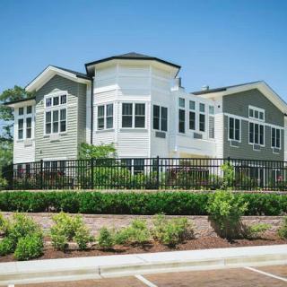 A modern residential house with large windows and landscaped surroundings.