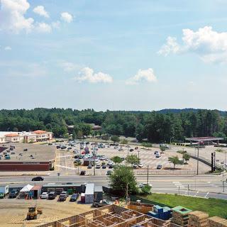 A view of a commercial area featuring a parking lot and ongoing construction.